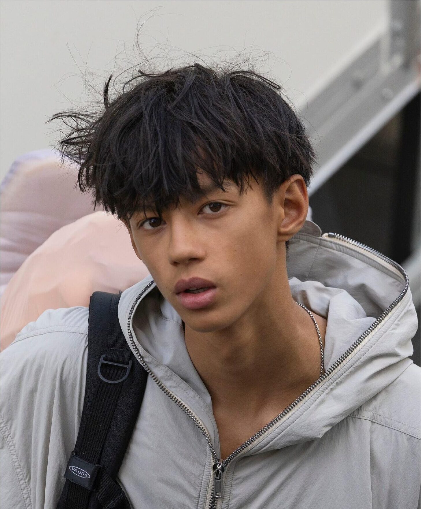 Close portrait of model in grey jacket with backpack
