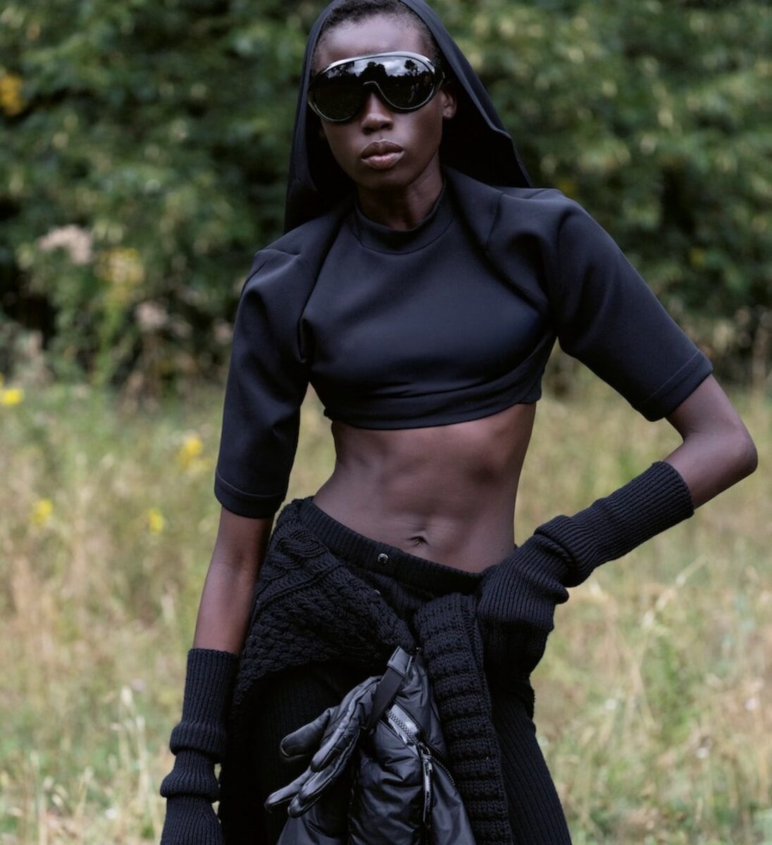 Model in black Moncler crop top and sunglasses, field backdrop