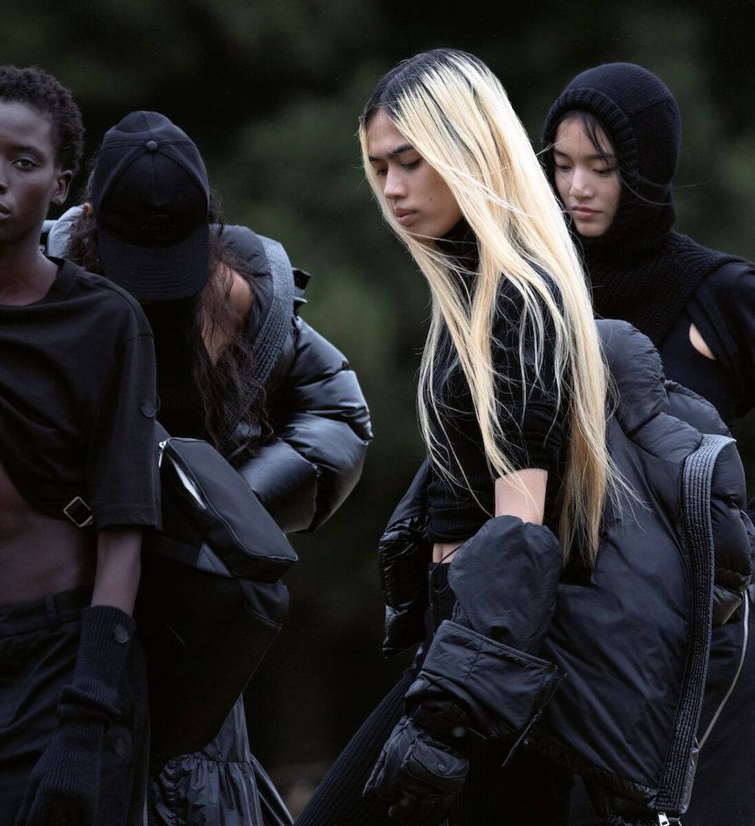 Close group of models in layered black Moncler